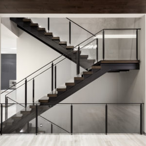 Double stringer stairway with wood steps and glass railing